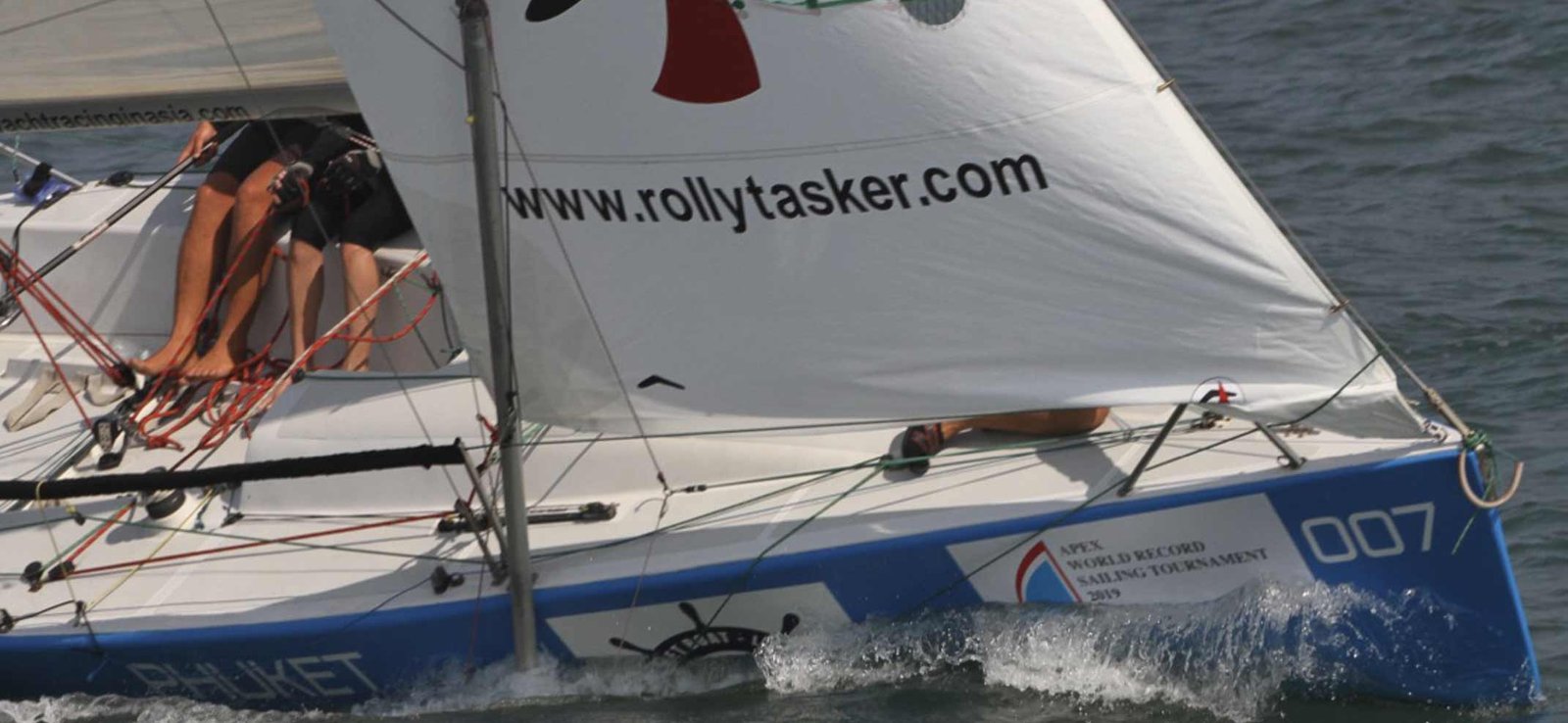 close up bow image of a sail in asia racing yacht under full speed.